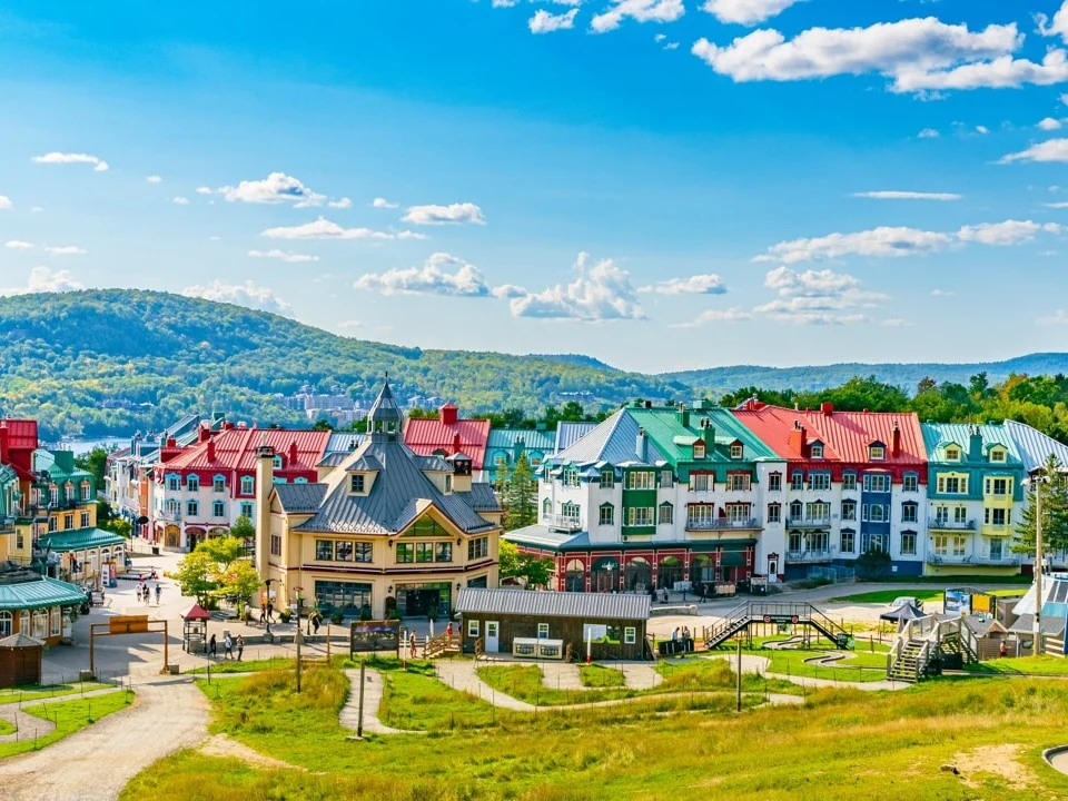 Chalets met gekleurde daken in het voetgangersgebied van skigebied Mont Tremblant met bergen op de achtergrond