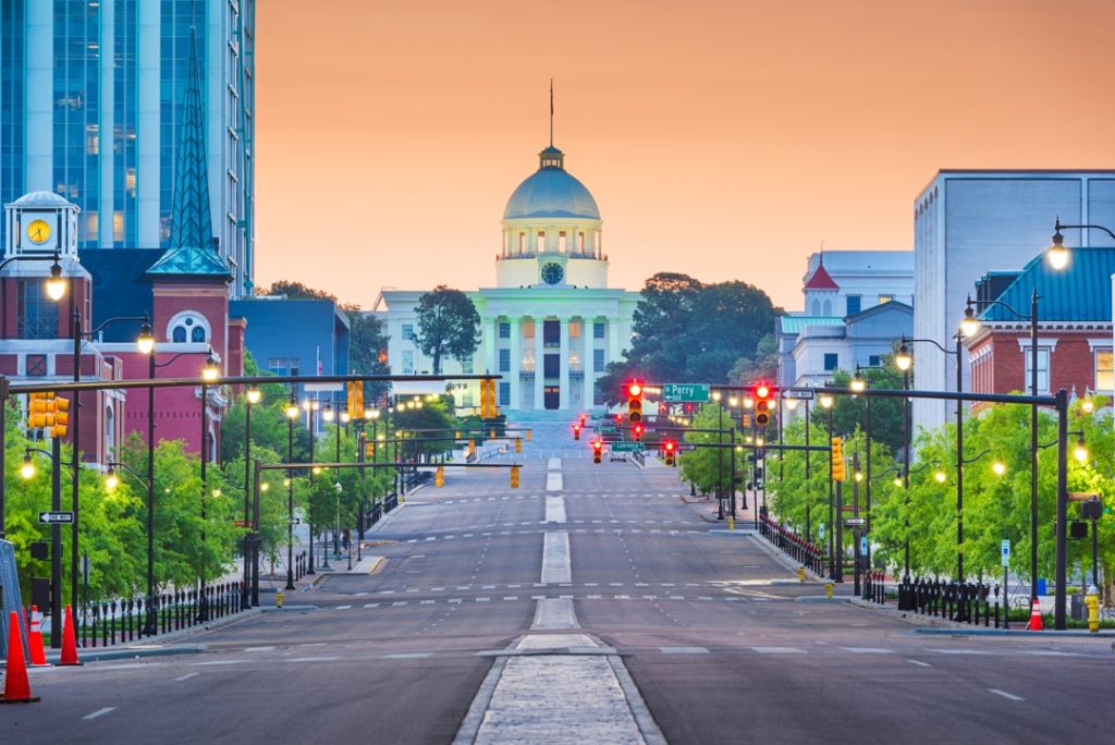 Lege straat met straatlantaarns die recht naar het verlichte Alabama State Capitol met koepel leidt in Montgomery bij het invallen van de avond