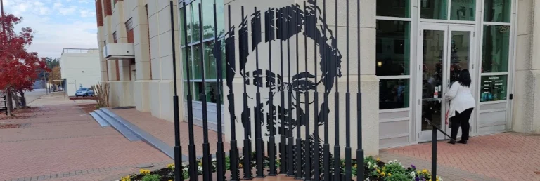 Straatkunstwerk in Montgomery waarbij een gezicht is vormgegeven met verticale zwarte stalen staven voor een gebouw