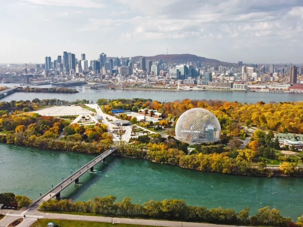 De koepelvormige Biosphère op een eiland in de rivier bij Montréal met de skyline en een brug op de achtergrond