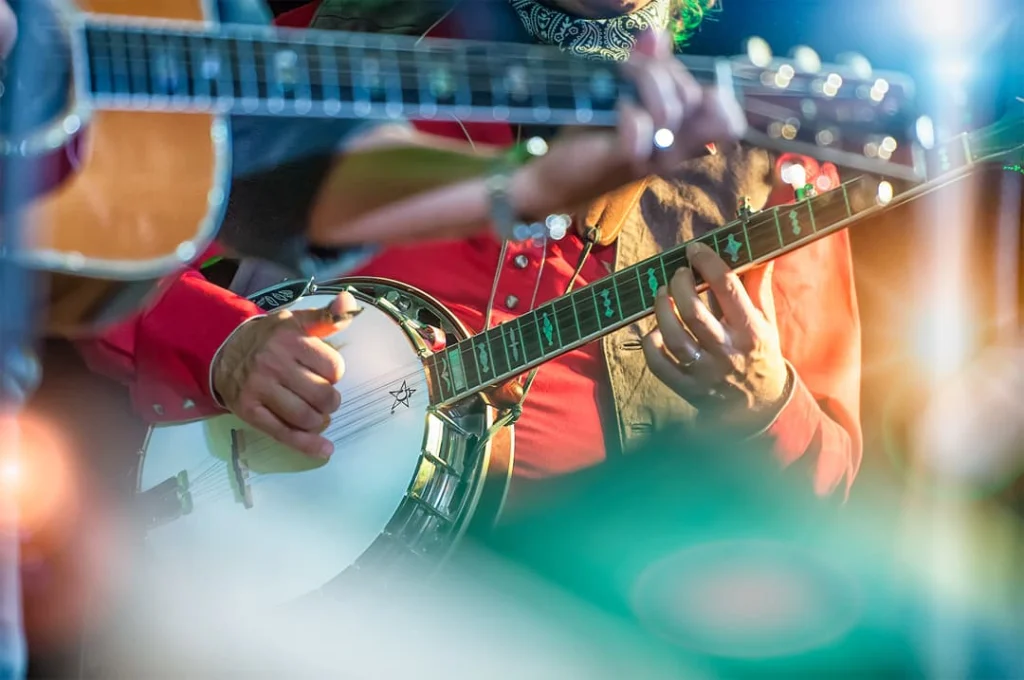 Close-up van muzikanten die tijdens een optreden in Muscle Shoals banjo en gitaar spelen in kleurrijke kleding