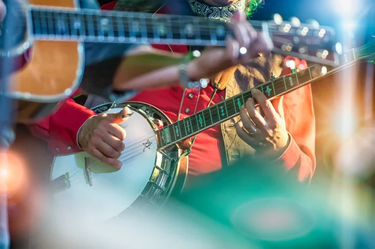 Close-up van muzikanten die tijdens een optreden in Muscle Shoals banjo en gitaar spelen in kleurrijke kleding