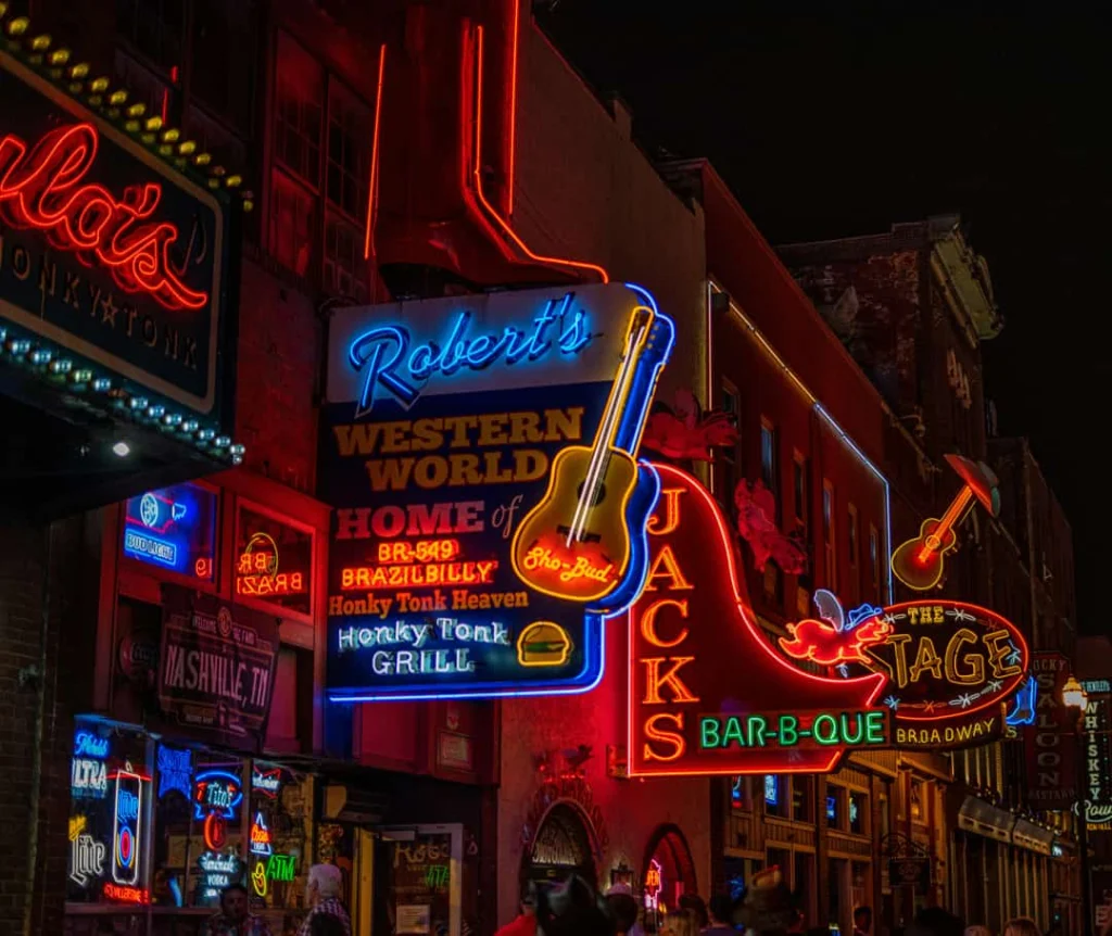 Close-up van felgekleurde neonreclames van countrybars langs Broadway in Nashville, verlicht tegen de avondlucht
