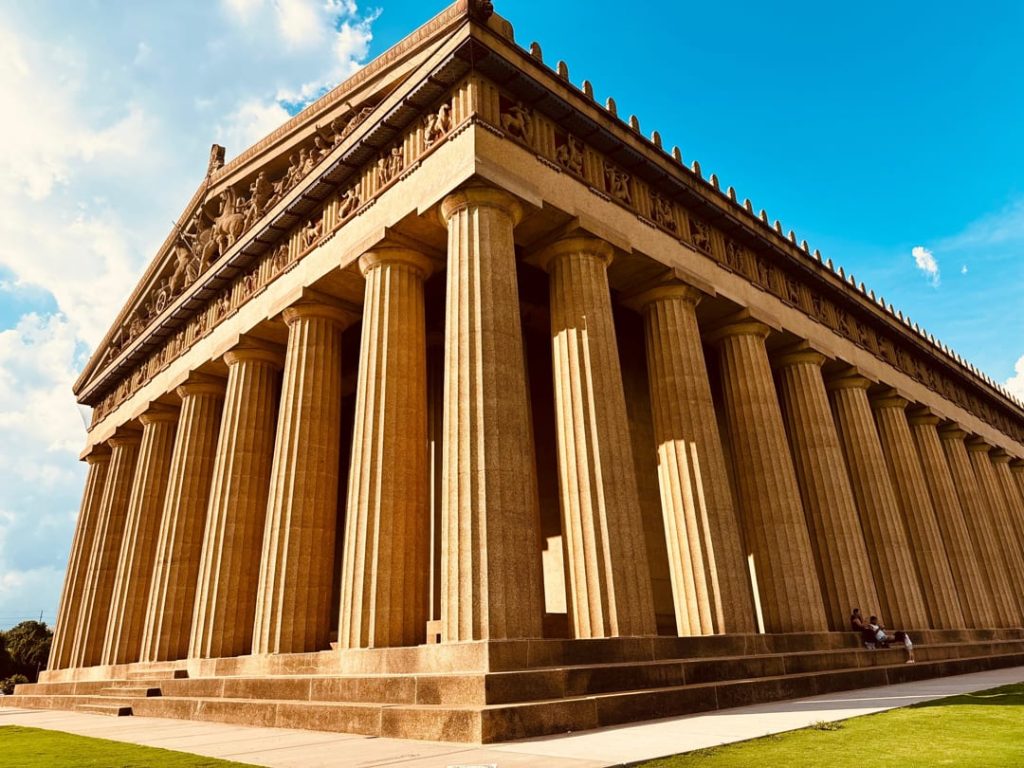 Detailopname van de hoge Dorische zuilen en het fries van de Parthenon replica in Nashville tegen een strakblauwe lucht