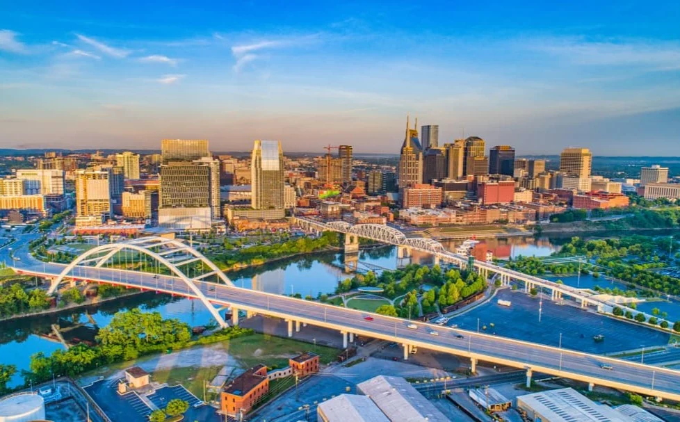 Luchtfoto van de skyline van Nashville in Tennessee met wolkenkrabbers, bruggen en de rivier bij zonsondergang