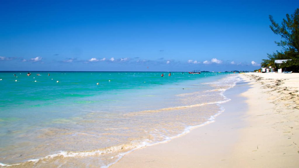 Leeg wit zandstrand in Negril met zachte golven en helder turquoise zeewater onder een strakblauwe lucht