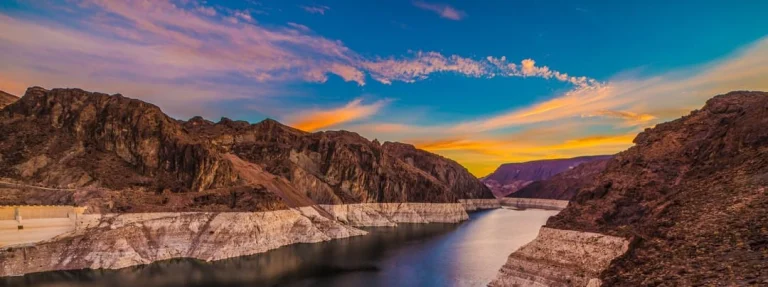 Kleurrijke zonsondergang boven de rotsachtige oevers en het water van Lake Mead in Nevada