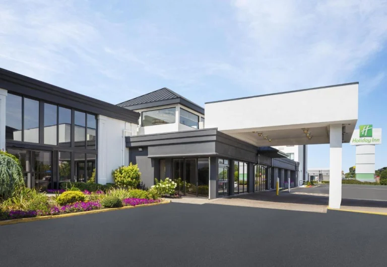 Modern hotelgebouw van Holiday Inn met een overdekte ingang en bloemperken bij een parkeerterrein in New Jersey