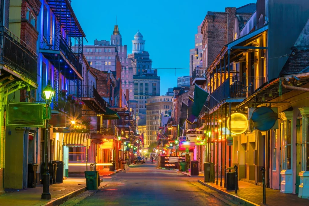 Verlichte straat met balkons en neonlampen van bars en restaurants in de French Quarter van New Orleans bij het vallen van de avond