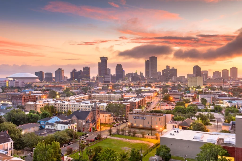 Uitzicht over de daken van New Orleans met wolkenkrabbers, de koepel van het Superdome en een kleurrijke lucht bij zonsondergang
