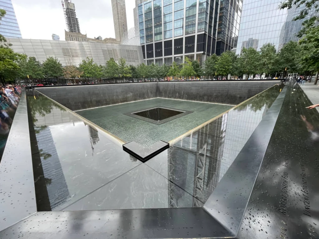 Vierkante reflecterende vijver met watervallen aan de randen en gegraveerde namen op de rand van het 9/11 Memorial