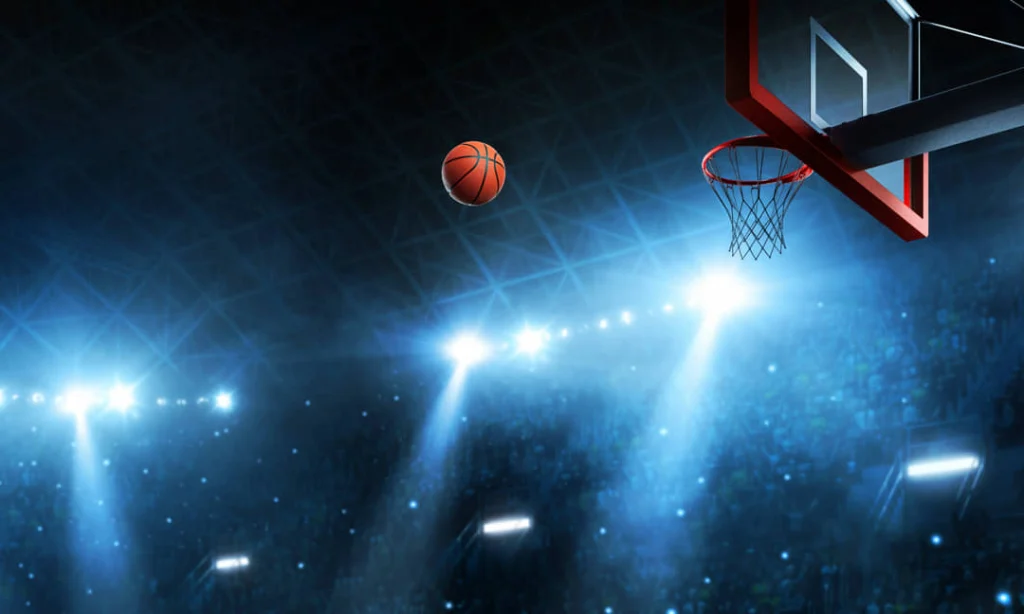 Een basketbal zweeft boven de ring van een basket in een sfeervol verlichte arena in New York