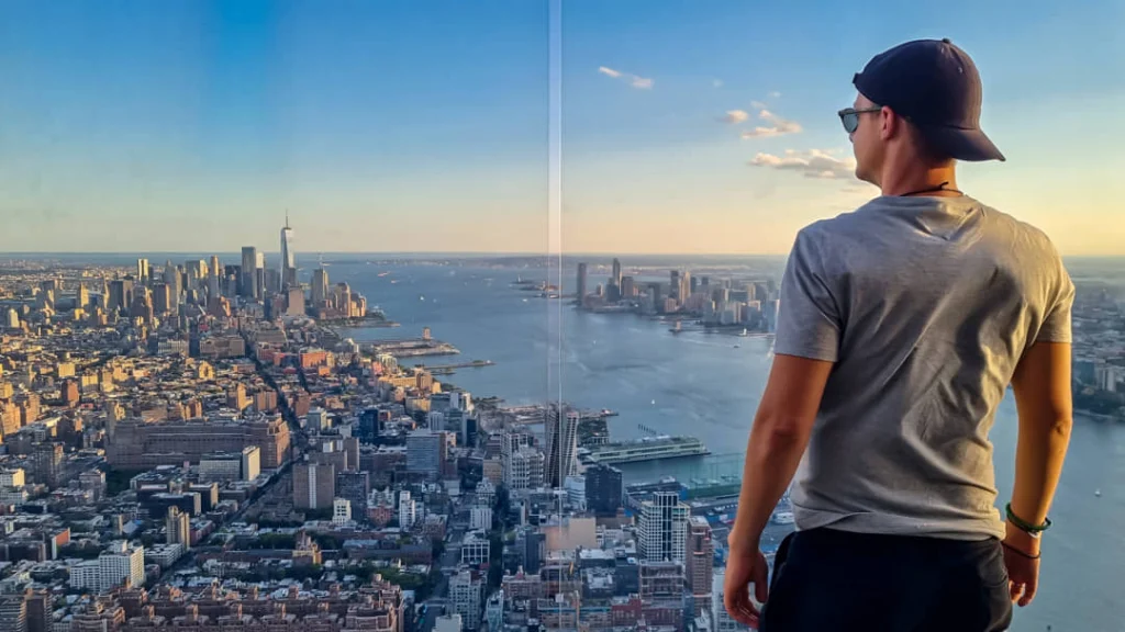 Man met pet en zonnebril kijkt met de rug naar de camera over de skyline van Manhattan bij zonsondergang