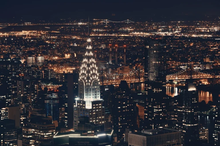 Verlichte Chrysler Building die 's nachts uitsteekt boven de skyline van Manhattan met talloze lichtjes van de stad eromheen