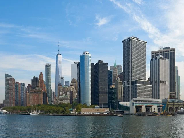Wolkenkrabbers van Lower Manhattan gezien vanaf een boot op het water, met een helderblauwe lucht in New York City