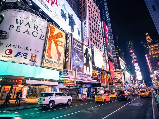 Drukke straat op Times Square in New York City bij nacht, met felgekleurde reclameborden, taxi's en voetgangers