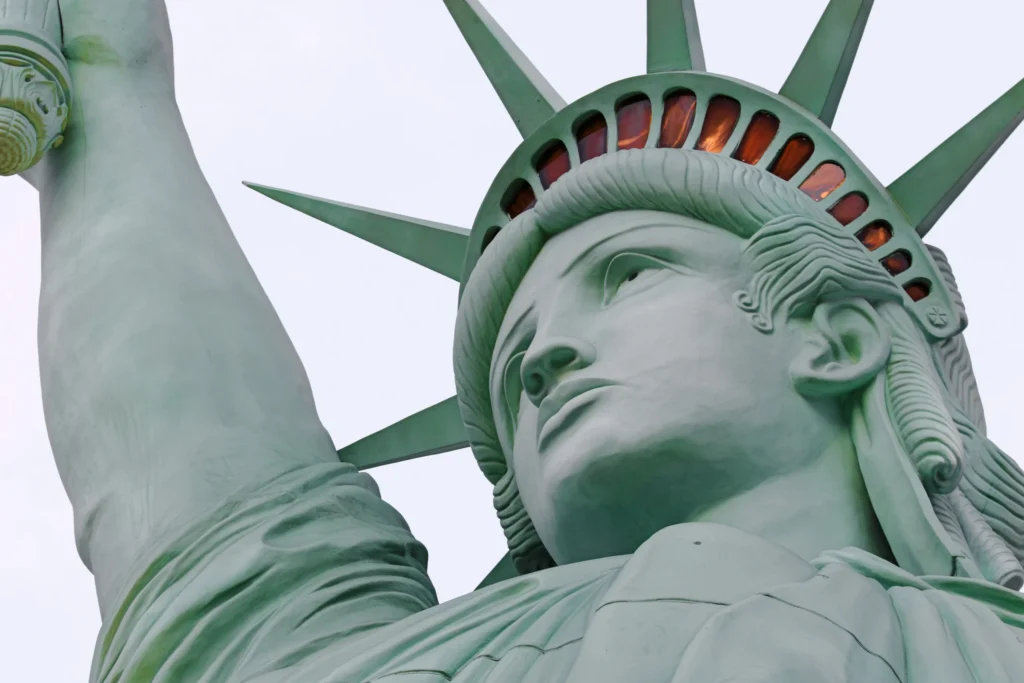 Close-up vanuit een lage hoek van het gezicht en de stralenkroon van het Vrijheidsbeeld in New York tegen een lichte lucht
