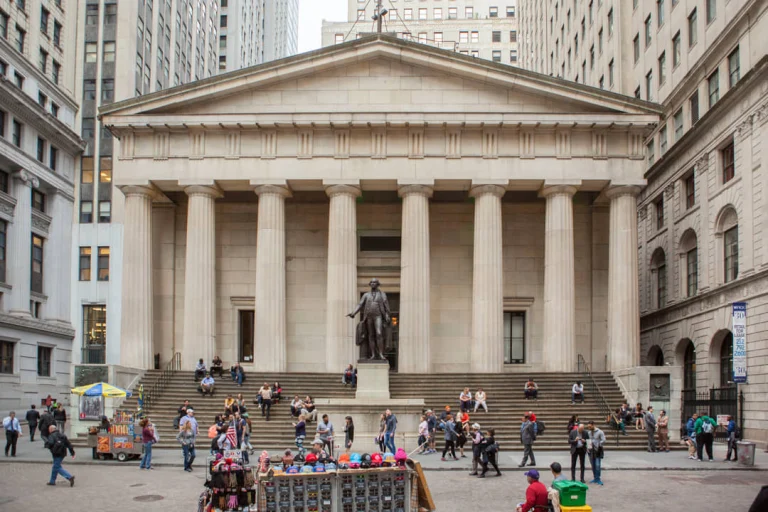 Voorgevel van Federal Hall met zuilen en het bronzen standbeeld van George Washington op de trappen in New York
