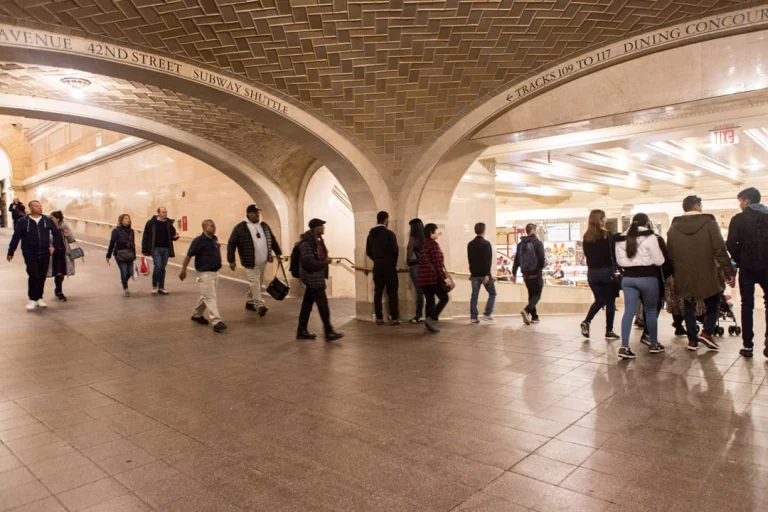 Laag gewelfde tegelgang met de tekst Vanderbilt Avenue 42nd Street Subway Shuttle waar reizigers doorheen lopen richting de dining concourse