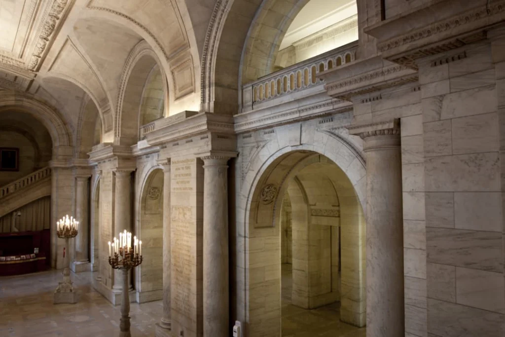 Gewelfde marmeren gang met bogen en een kandelaar met kaarsen in de New York Public Library
