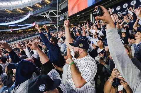 Een uitverkocht Yankee Stadium in New York waar enthousiaste fans in het blauw en wit juichen en applaudisseren tijdens de wedstrijd