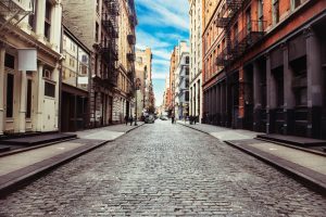 Lege kasseienstraat met aan weerszijden gietijzeren gevels van pakhuizen in de wijk SoHo in New York