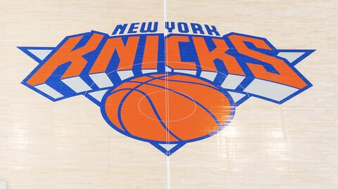 Close-up van het oranje en blauwe New York Knicks logo geschilderd op de houten vloer van de basketbalarena