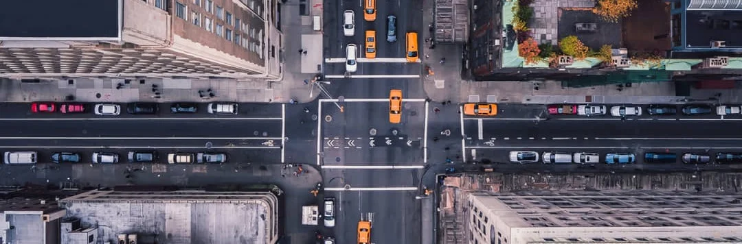 Vogelvluchtperspectief op een druk kruispunt in New York met gele taxi's tussen hoge gebouwen