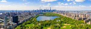 Breed luchtfoto panorama van het groene Central Park met een meer, sportvelden en de wolkenkrabbers van Manhattan aan weerszijden