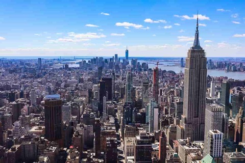 Brede luchtfoto over de dichte wolkenkrabbers van Manhattan met de Empire State Building op de voorgrond overdag