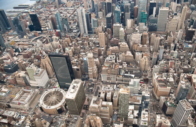 Luchtfoto van dichtbebouwde straten en gebouwen in Manhattan met het ronde dak van Madison Square Garden in beeld