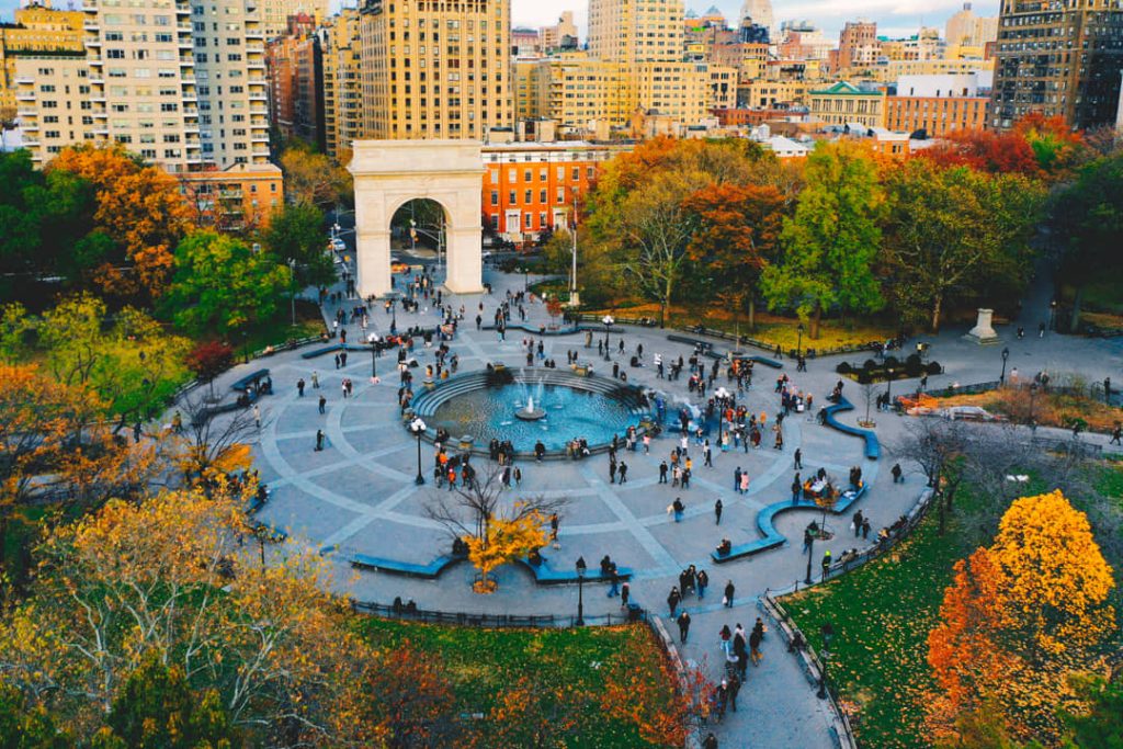 Luchtfoto van de fontein en de boog van Washington Square Park omringd door bomen in herfstkleuren en gebouwen in New York
