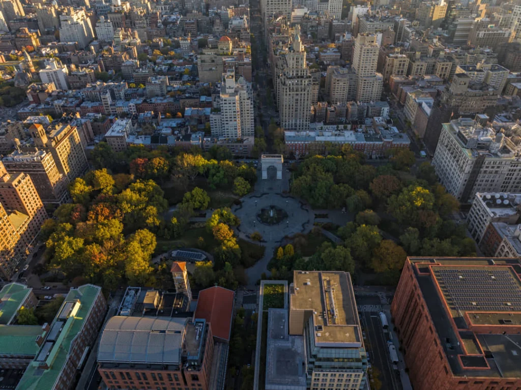 Luchtzicht op Washington Square Park in New York met de boog, straten en omliggende gebouwen bij zonsondergang