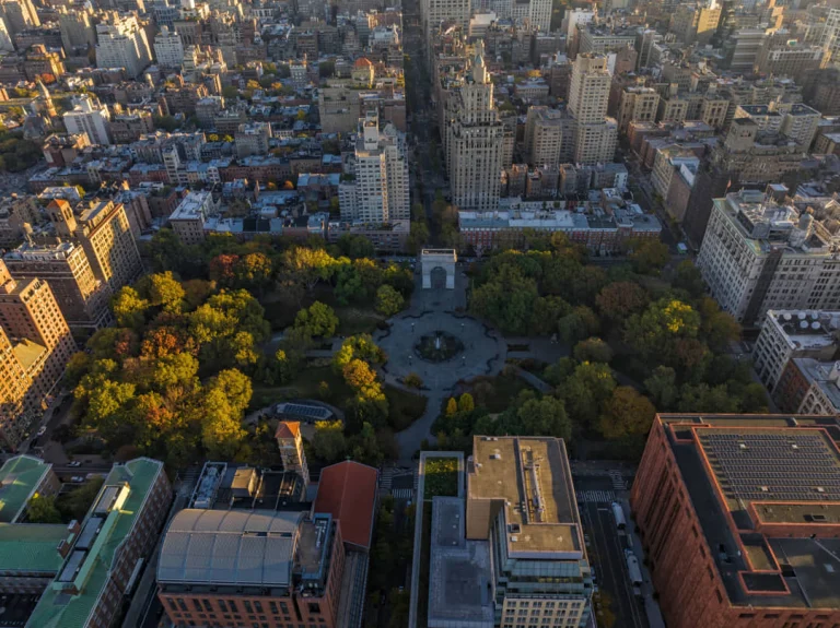 Luchtzicht op Washington Square Park in New York met de boog, straten en omliggende gebouwen bij zonsondergang