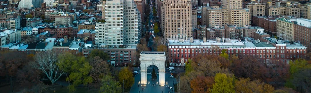 Luchtzicht op Washington Square Park in New York met de boog, herfstkleurige bomen en omliggende gebouwen