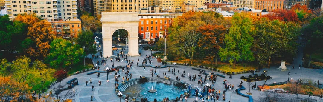 Luchtfoto van Washington Square Park met de triomfboog, een fontein en herfstbladeren tussen de omringende gebouwen van Greenwich Village