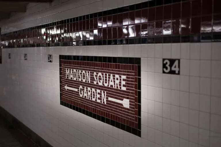 Tegelbord met de tekst Madison Square Garden en een pijl in een ondergrondse stationstunnel in New York