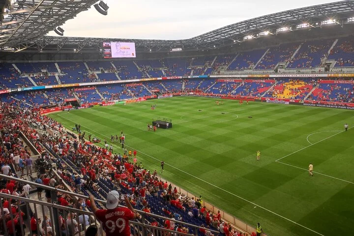 Overzicht van het speelveld en de volle tribunes van de Red Bull Arena in New York tijdens een voetbalwedstrijd