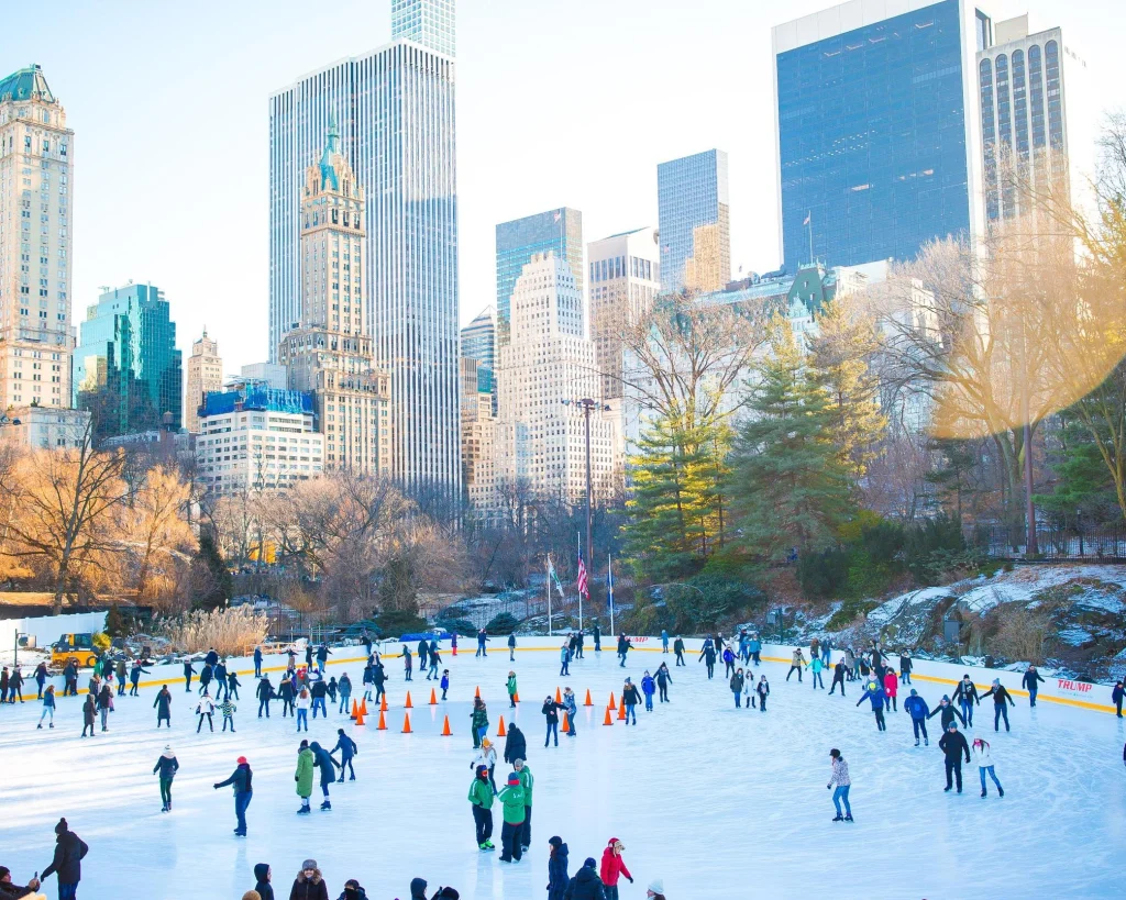 Mensen schaatsen op een buitenijsbaan in Central Park in New York met de skyline van Manhattan op de achtergrond