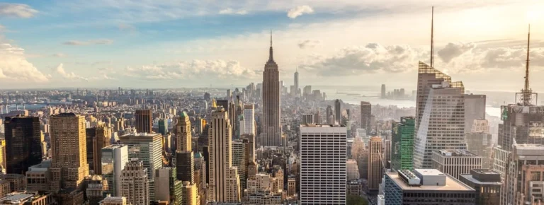 Panoramisch uitzicht op de wolkenkrabbers van New York met de Empire State Building op de achtergrond bij zonsondergang