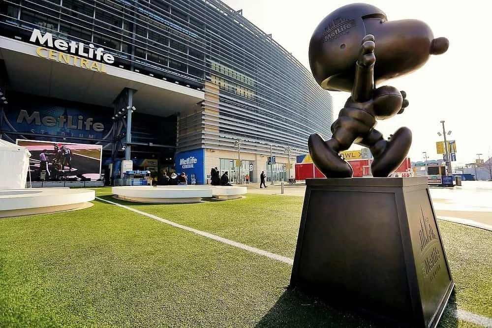 Een bronzen standbeeld van Snoopy staat op een sokkel voor de ingang van MetLife Stadium in New York