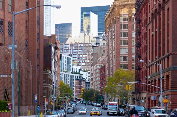 Blik door een straat in TriBeca met taxi's en auto's tussen rode bakstenen pakhuizen en moderne hoogbouw op de achtergrond