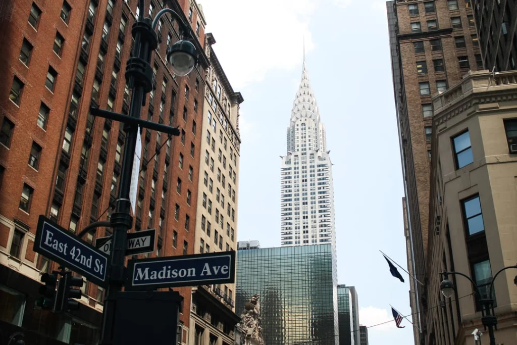 Straatborden met de tekst East 42nd Street en Madison Avenue met de spits van de Chrysler Building zichtbaar erachter