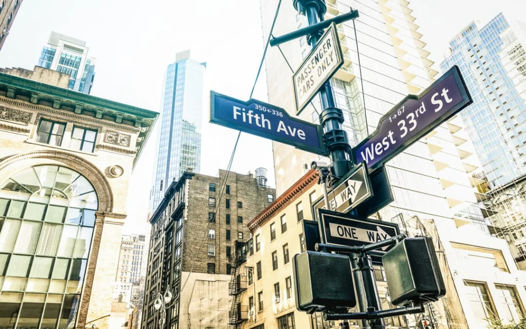 Kruispuntbordjes met de namen Fifth Avenue en West 33rd Street tegen een achtergrond van hoge gebouwen in New York
