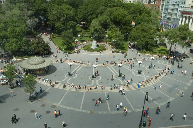 Luchtzicht op Union Square Park in New York overdag met groene bomen, een kiosk en tientallen wandelende bezoekers