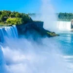 Brede, schuimende watervallen van Niagara Falls met wolkenkrabbers van de stad zichtbaar op de achtergrond