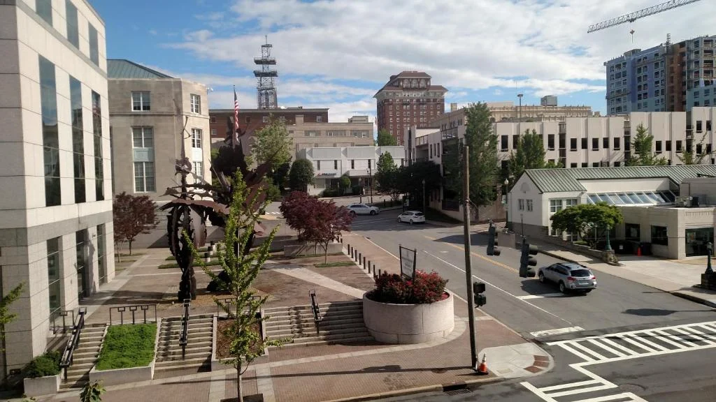 Vogelperspectief op een kruising met gebouwen, bomen en een klokkentoren in een stadscentrum in North Carolina