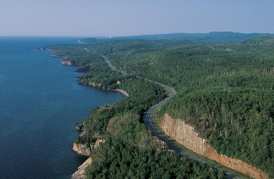 Luchtfoto van een kustweg die door beboste heuvels langs Lake Superior slingert bij Tettegouche State Park