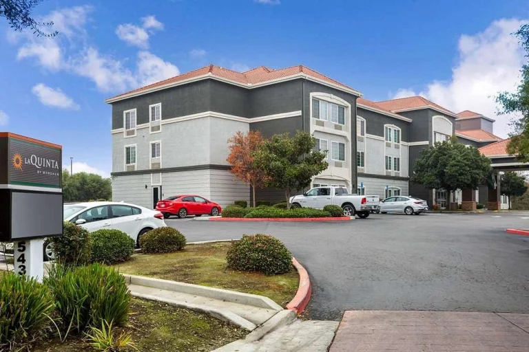 Gevel van een La Quinta hotel met rode auto's op de parkeerplaats en een blauwe lucht met wolken in Ohio