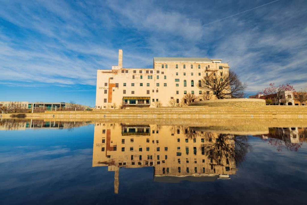 Wit gebouw van het Oklahoma City National Memorial weerspiegeld in de rustige reflecterende vijver ervoor